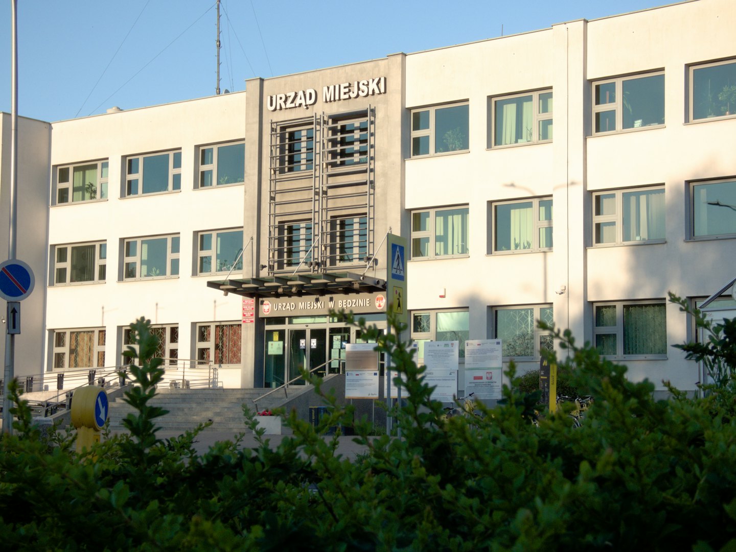 Modern municipal building with a wide staircase and signage.